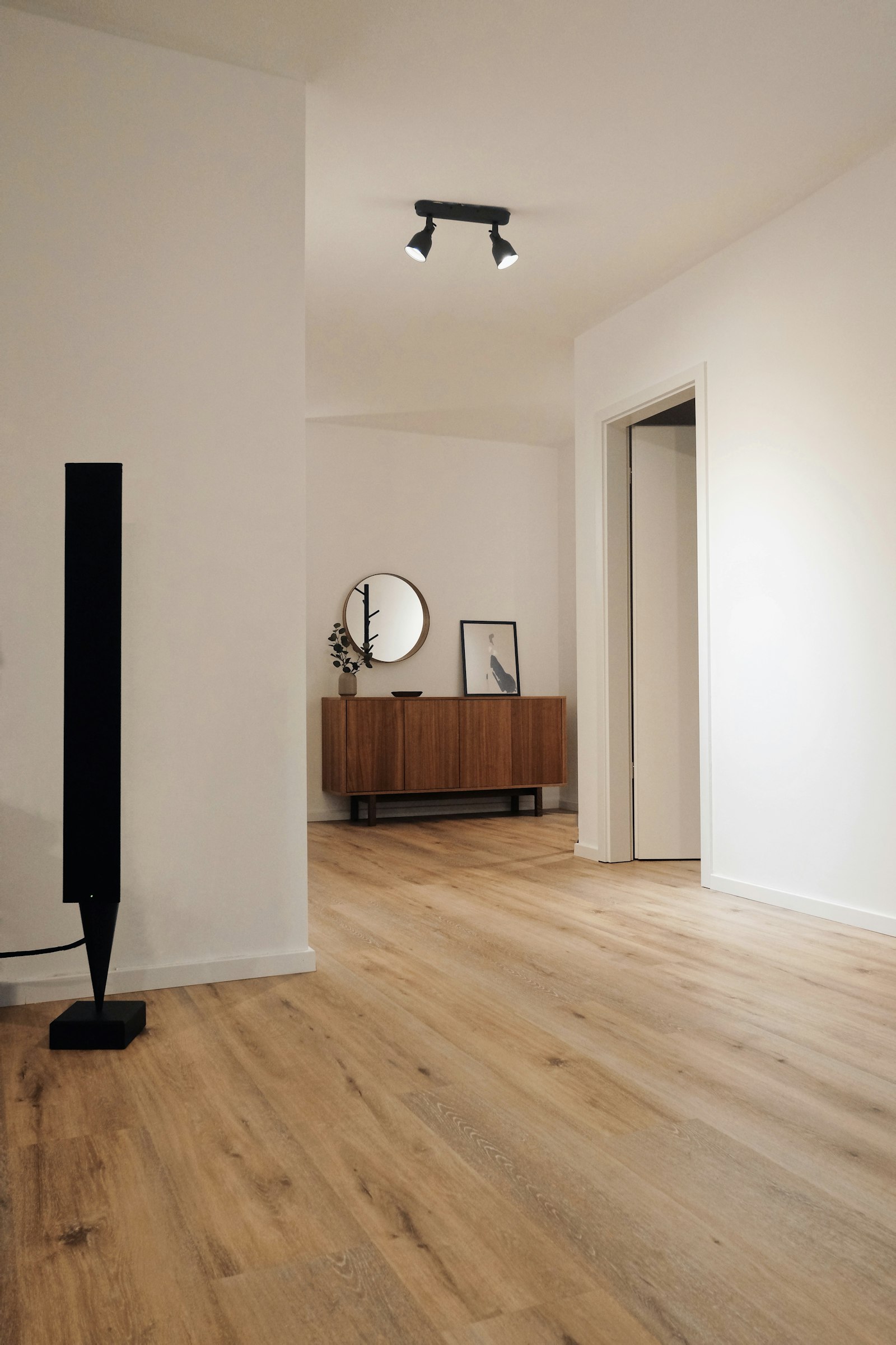 Hall rénové, murs blancs lisses et parquet chêne clair